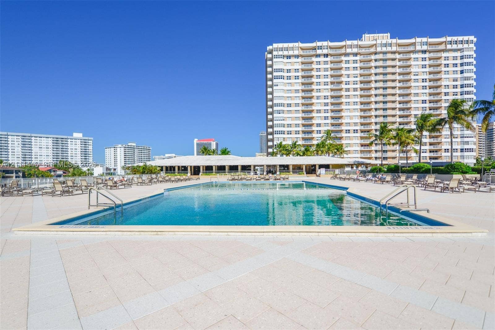 1965 S Ocean Drive, #15M, Hallandale Beach, Hallandale Beach, FL 33009 In-ground swimming pool featuring a concrete deck, metal handrails, and surrounding palm trees