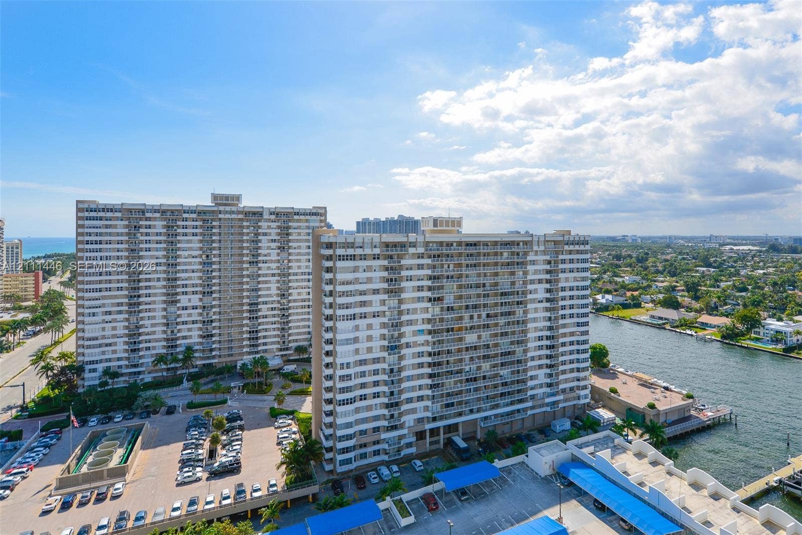 1965 S Ocean Drive, #15M, Hallandale Beach, Hallandale Beach, FL 33009 High-rise residential complex featuring private balcony tiers, covered surface parking structures, waterfront positioning, and integrated exterior lighting