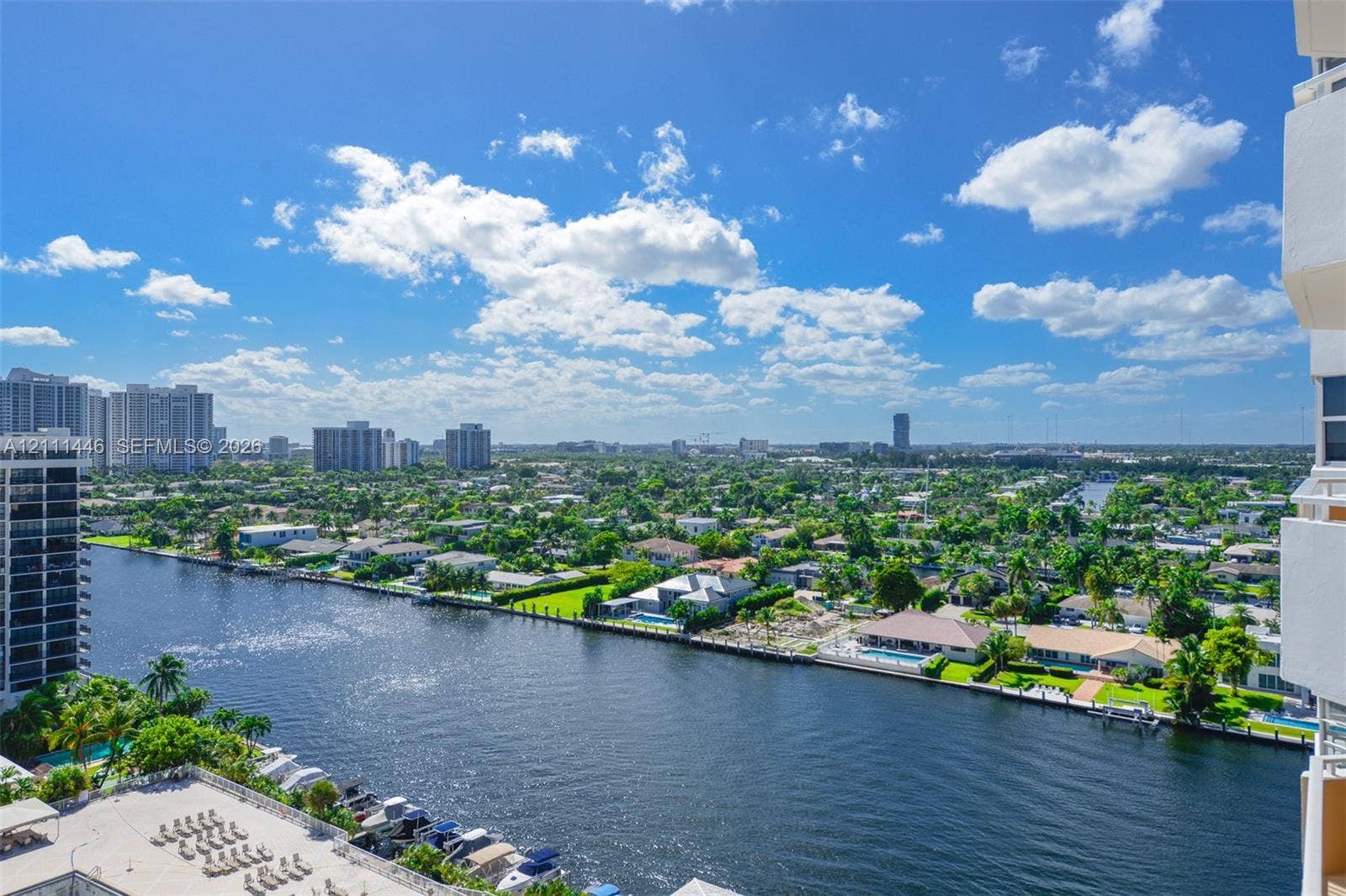 1965 S Ocean Drive, #15M, Hallandale Beach, Hallandale Beach, FL 33009 Elevated exterior vantage point featuring an expansive waterway, multiple boat slips, manicured landscape, and an urban skyline