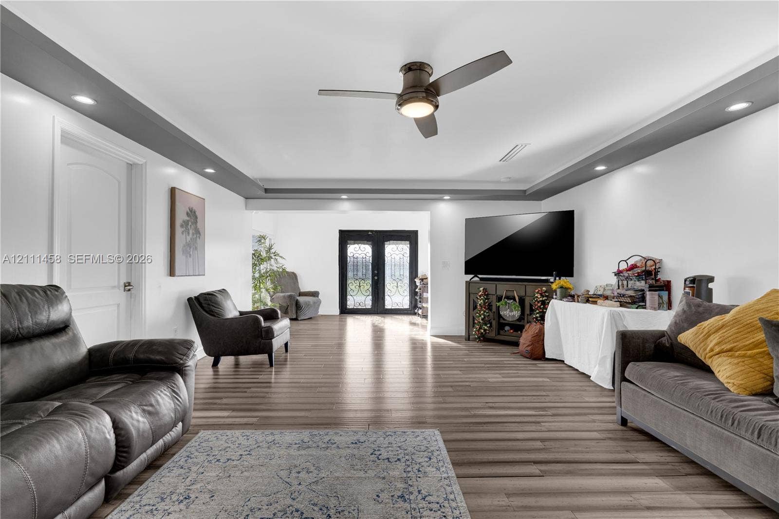 17135 NW 19th Avenue, Miami Gardens, FL 33056 Interior space featuring tray ceiling with recessed lighting, double entry doors with decorative iron detailing, and a central ceiling fan