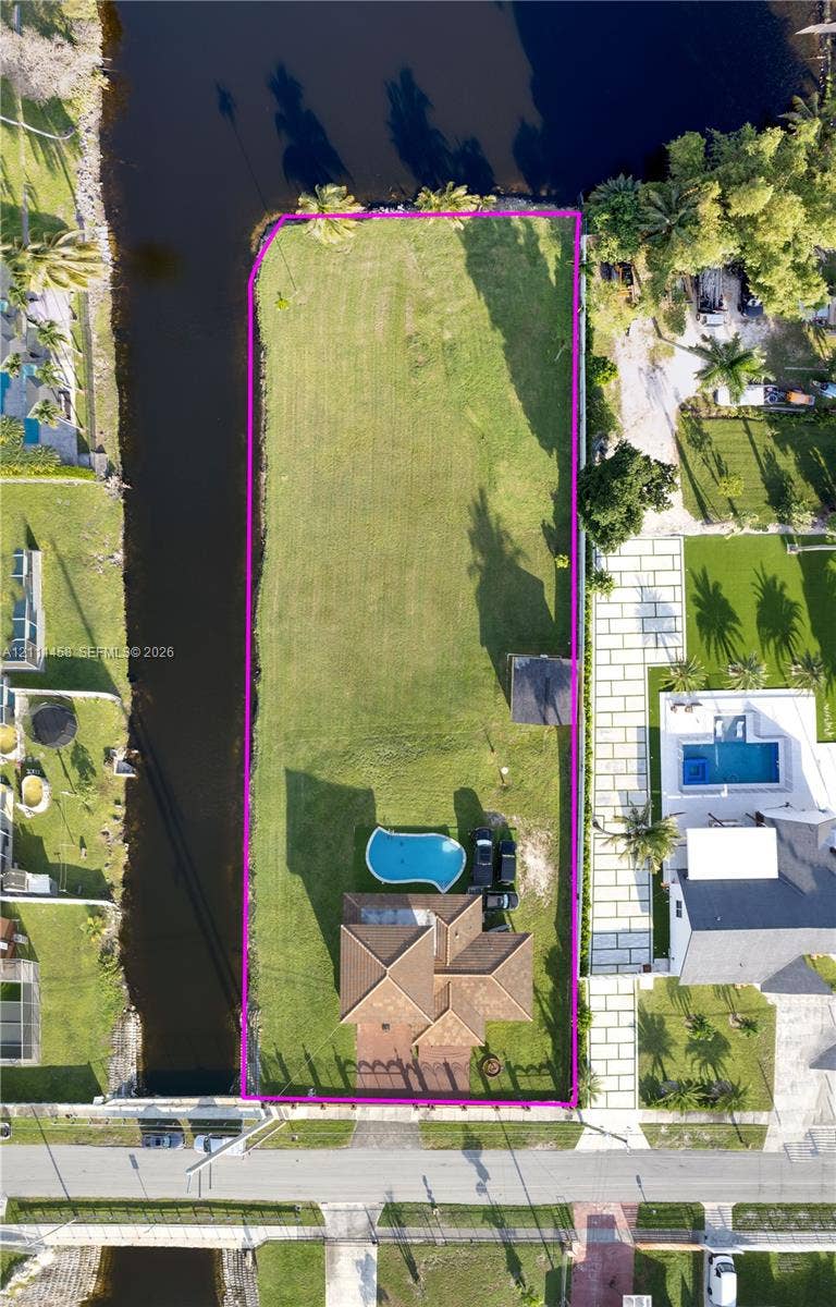17135 NW 19th Avenue, Miami Gardens, FL 33056 Waterfront lot featuring a private swimming pool, expansive lawn