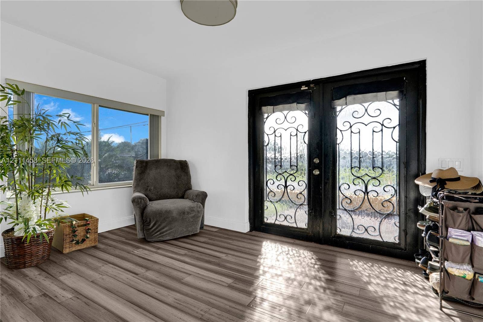 17135 NW 19th Avenue, Miami Gardens, FL 33056 Double entry doors featuring decorative black iron grillwork, wood-finish flooring, and a large horizontal window