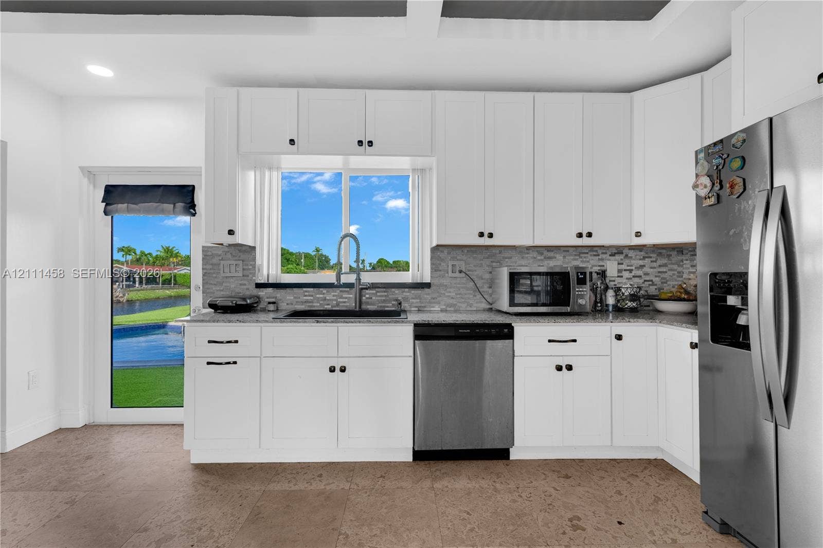 17135 NW 19th Avenue, Miami Gardens, FL 33056 Kitchen featuring white cabinetry, stone-surface countertops, stone-tile backsplash, stainless steel appliances,