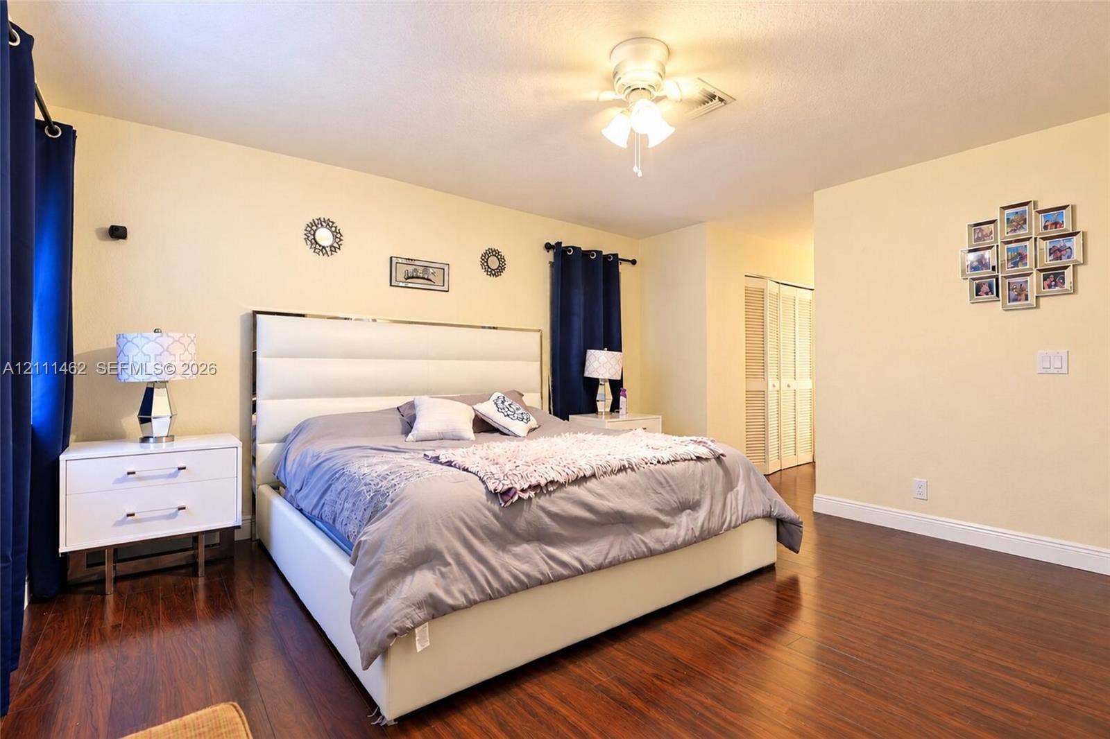 Bedroom featuring wood-finish flooring, ceiling-mounted light fixture, and bi-fold closet doors