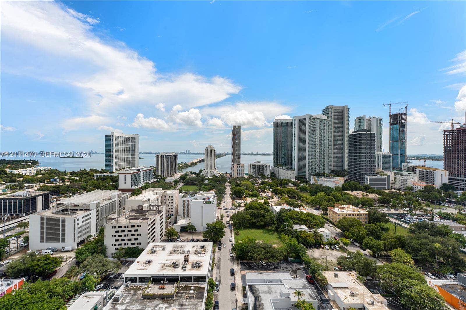 High-rise aerial perspective featuring an expansive cityscape, unobstructed water horizon, and coastal skyline