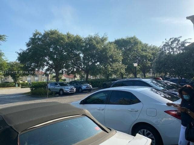 11101 Royal Palm Boulevard, #113, Coral Springs, Coral Springs, FL 33065 Paved surface parking area with designated stalls, mature trees, and installed exterior lighting