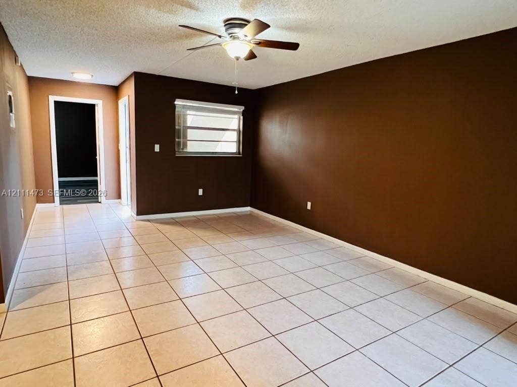 11101 Royal Palm Boulevard, #113, Coral Springs, Coral Springs, FL 33065 Neutral ceramic tile flooring, ceiling fan with integrated lighting, and horizontal window blinds