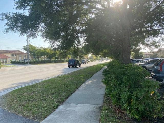 11101 Royal Palm Boulevard, #113, Coral Springs, Coral Springs, FL 33065 Concrete sidewalk bordered by mature shade trees, established shrubbery, and a grass lawn