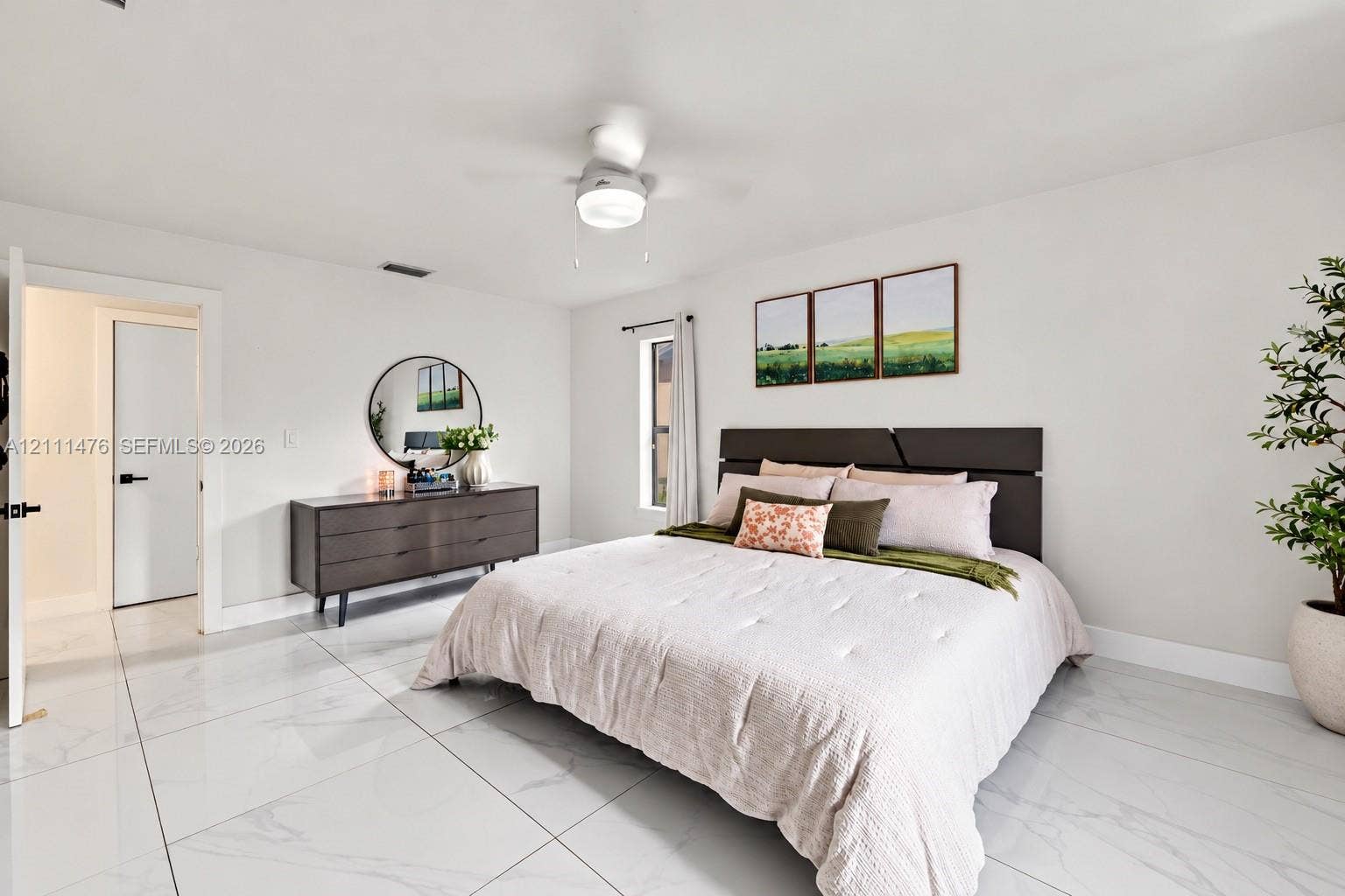 Large-format polished tile flooring, neutral wall tones, and a ceiling-mounted light fixture with an integrated fan