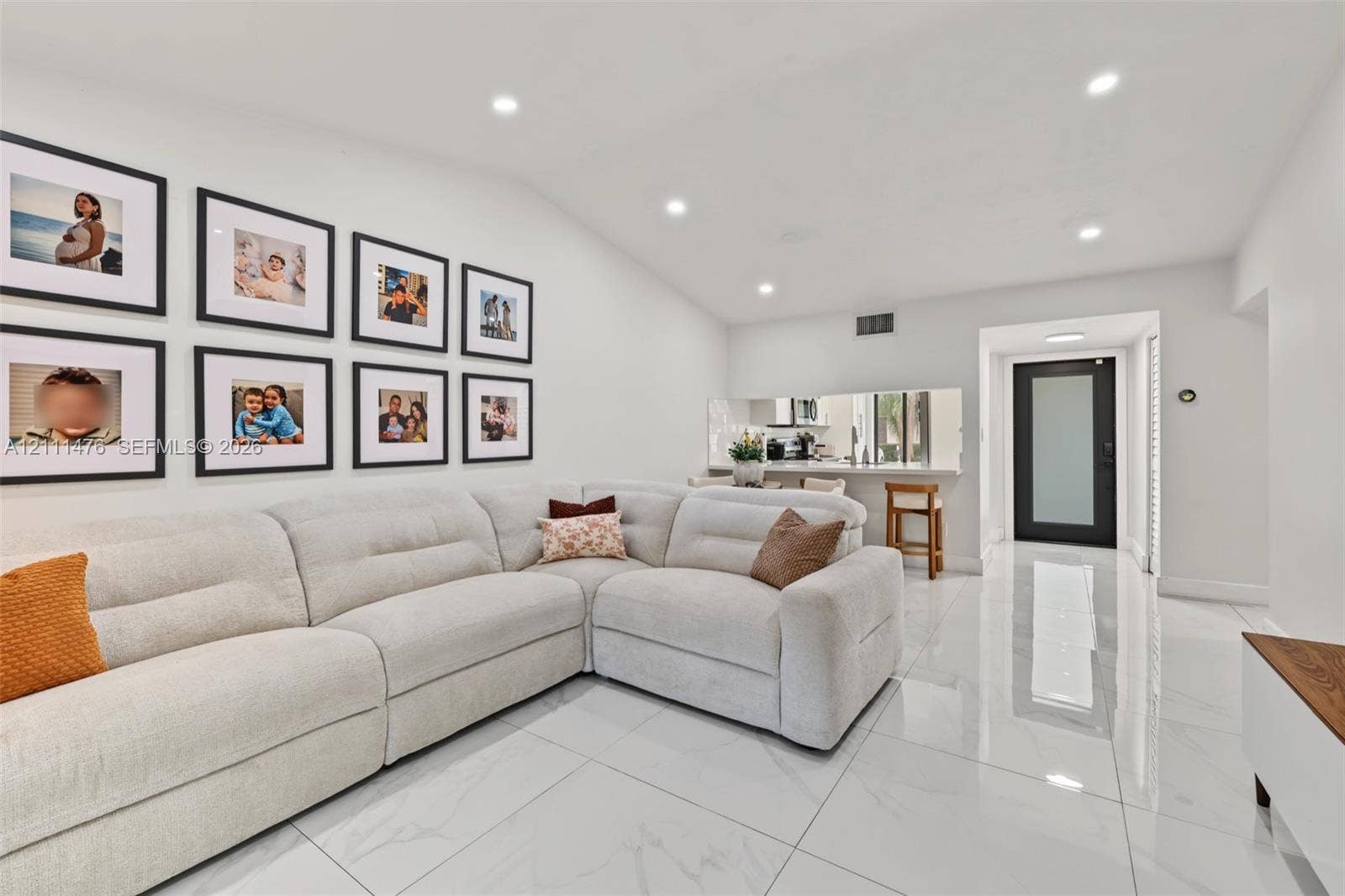 Large-format tile flooring, recessed lighting, and an exterior door featuring a frosted glass panel