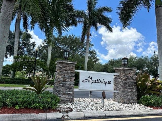 3210 SE 6th Street, Homestead, Homestead, FL 33033 Community entrance featuring stacked-stone pillars, capped lantern-style lighting, and mature palm landscaping.