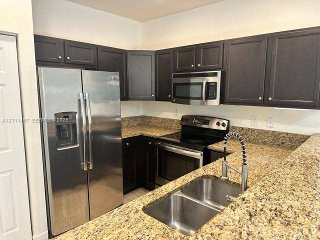 3210 SE 6th Street, Homestead, Homestead, FL 33033 Kitchen featuring dark-finish cabinetry, stone-composite countertops, stainless steel appliances, a double-basin under-mount sink, and a gooseneck pull-down faucet