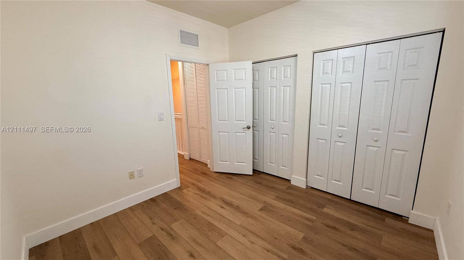 3210 SE 6th Street, Homestead, Homestead, FL 33033 Interior room featuring wood-finish flooring, six-panel interior doors, and double-door closet storage