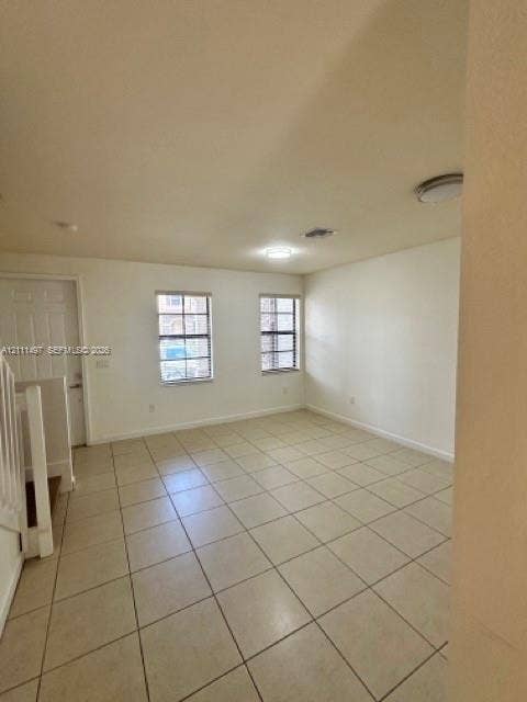 3210 SE 6th Street, Homestead, Homestead, FL 33033 Open interior space featuring light-toned tile flooring, two double-hung windows with horizontal blinds, neutral wall finishes, and flush-mount ceiling lighting