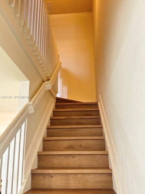 3210 SE 6th Street, Homestead, Homestead, FL 33033 Staircase featuring wood-finish treads and white painted handrails with matching vertical balusters