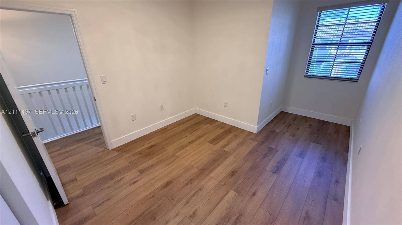 3210 SE 6th Street, Homestead, Homestead, FL 33033 Room featuring wood-finish flooring, neutral wall paint, and a single-pane window with installed blinds