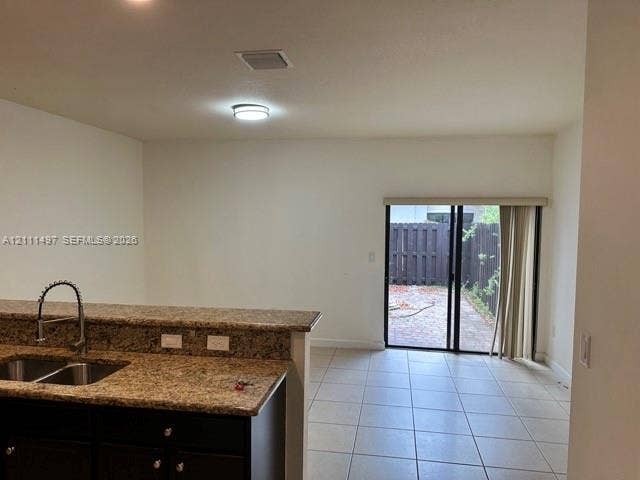 3210 SE 6th Street, Homestead, Homestead, FL 33033 Kitchen featuring stone countertops, a dual-basin undermount sink with a gooseneck faucet, and dark wood-finish cabinetry