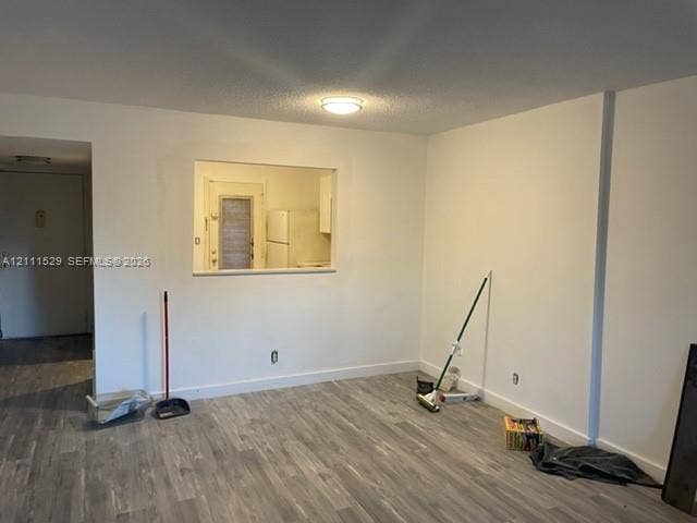 406 NW 68th Avenue, #118, Plantation, Plantation, FL 33317 Open-concept interior featuring wood-finish flooring, neutral wall tones, and a pass-through window with a flush-mount ceiling light fixture
