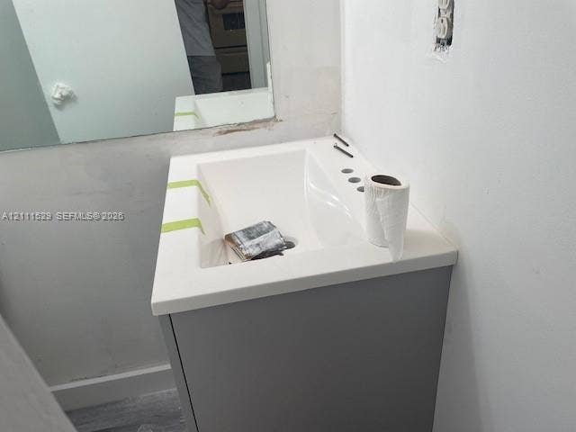406 NW 68th Avenue, #118, Plantation, Plantation, FL 33317 Single-sink vanity featuring a solid-surface countertop with an integrated basin and a neutral grey cabinet base, paired with a wall-mounted rectangular mirror