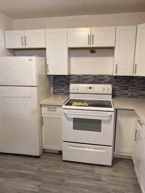 406 NW 68th Avenue, #118, Plantation, Plantation, FL 33317 Kitchen featuring white cabinetry with brushed metal pulls, light-toned countertops, multi-tonal linear backsplash, and wood-finish flooring