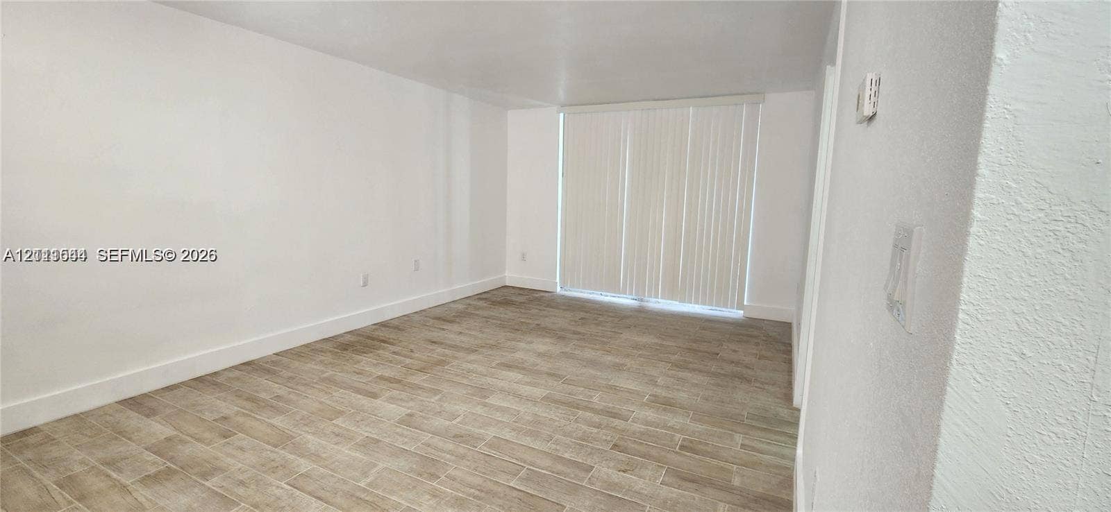 19771 SW 114th Avenue, #227, Miami, Miami, FL 33157 Interior room featuring neutral wall paint, wood-finish tile flooring, and vertical window blinds