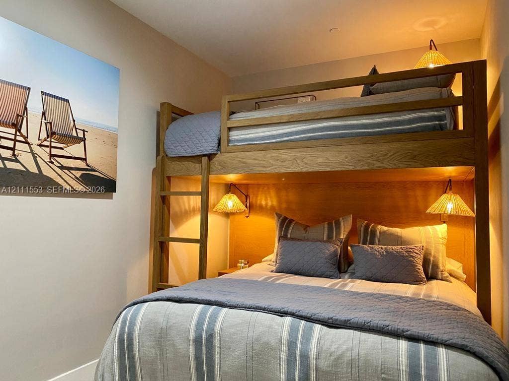 Custom-built wooden bunk structure with an integrated ladder and wall-mounted light fixtures
