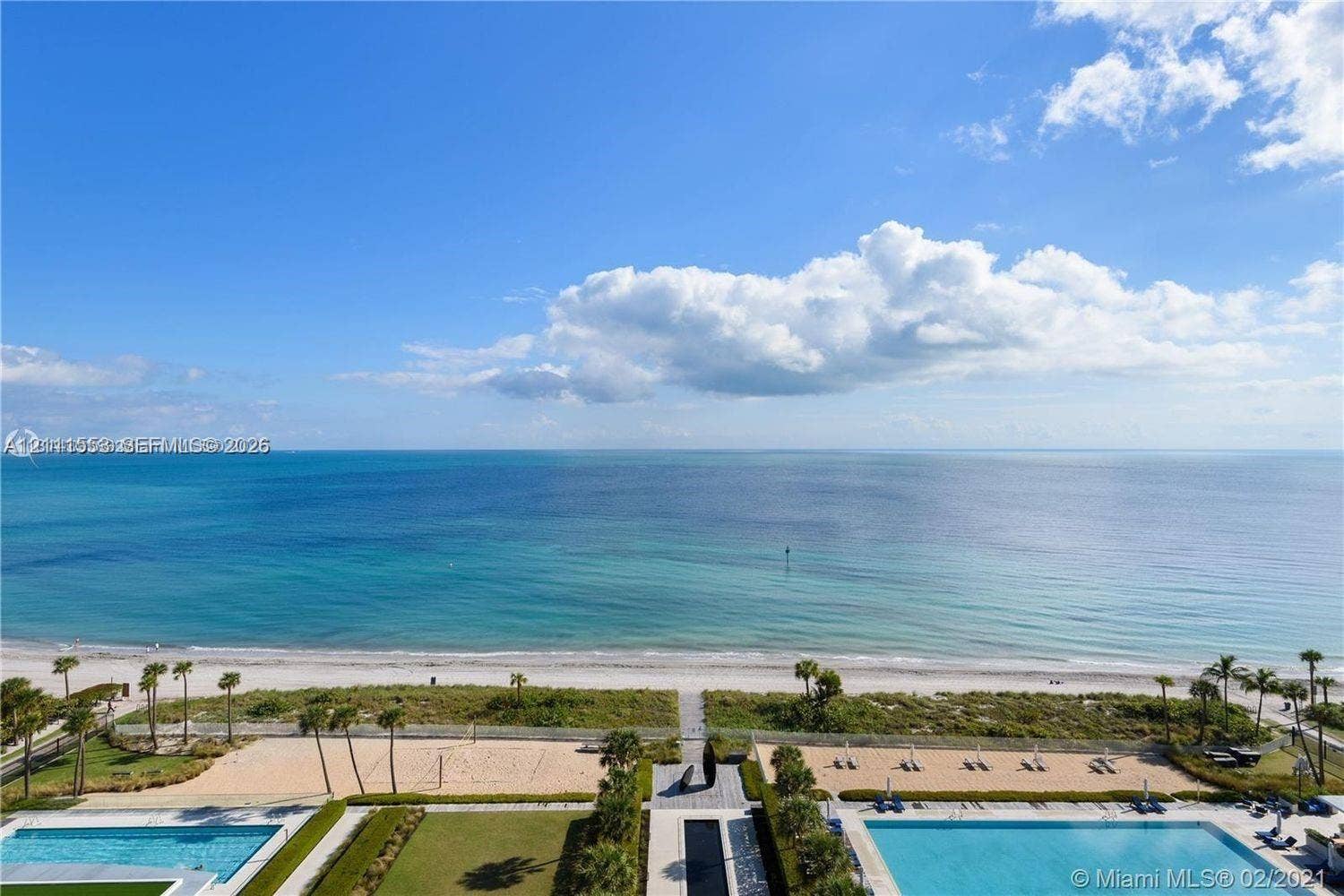 Oceanfront property featuring two outdoor swimming pools, manicured green space, sand volleyball courts, and direct beach access