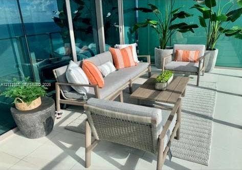 Covered balcony featuring expansive glass panel railings and large-format porcelain tile flooring