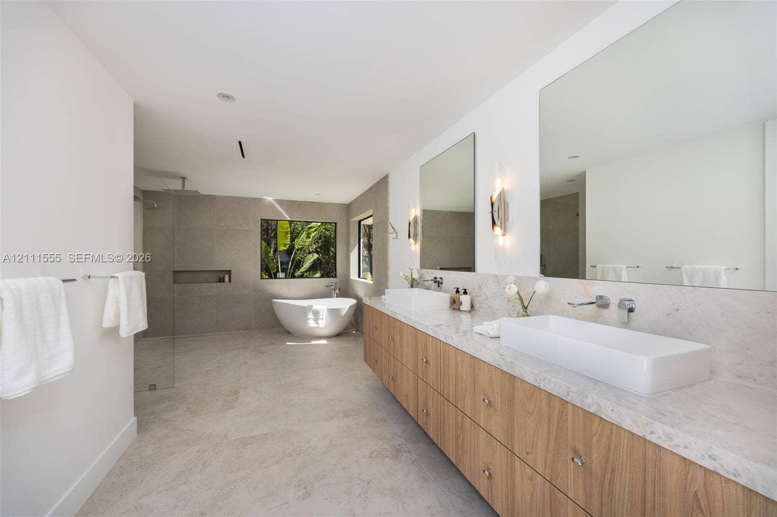 8800 SW 118th Street, Miami, Miami, FL 33176 Floating dual vanity with stone-finish countertops, rectangular vessel sinks, wall-mounted faucets, large-format tile flooring, and a freestanding soaking tub