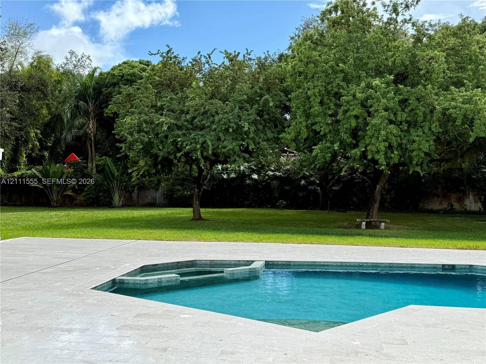 8800 SW 118th Street, Miami, Miami, FL 33176 Swimming pool with integrated spa and stone-finish decking, set against a manicured lawn with mature trees