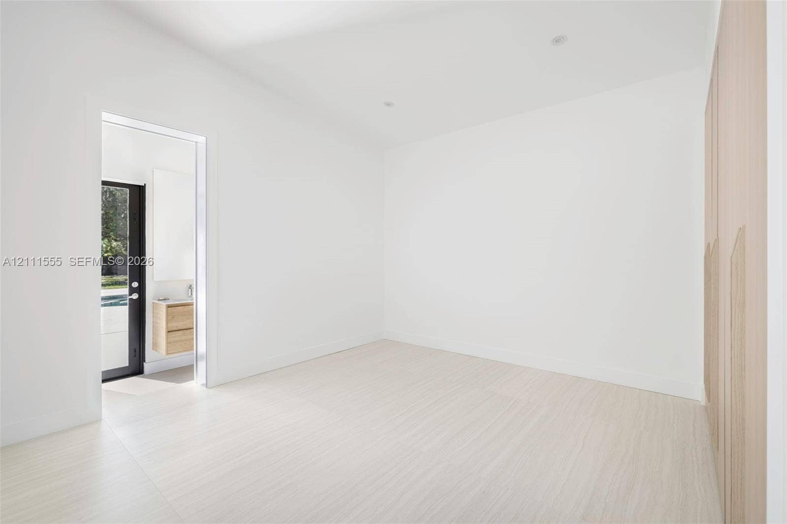8800 SW 118th Street, Miami, Miami, FL 33176 Minimalist room featuring wood-finish flooring, integrated floor-to-ceiling cabinetry, recessed lighting, and a glass-paneled exterior door