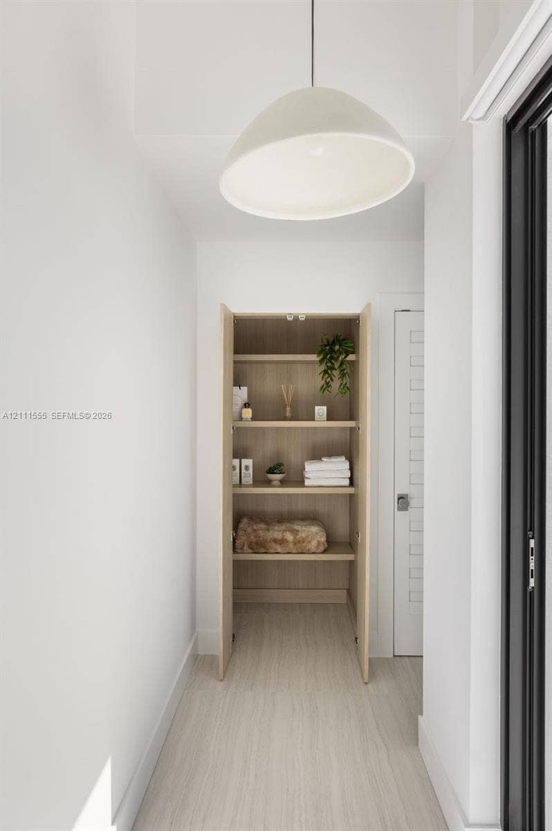 8800 SW 118th Street, Miami, Miami, FL 33176 Built-in cabinetry featuring natural wood finish, four open shelves, minimalist dome pendant lighting, and wood-finish flooring