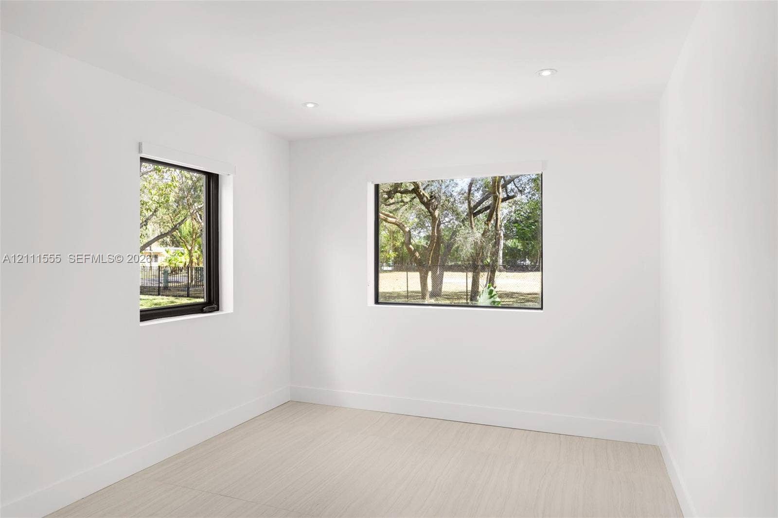 8800 SW 118th Street, Miami, Miami, FL 33176 Bright interior space featuring neutral walls, light wood-finish flooring, recessed lighting, and large windows with black frames