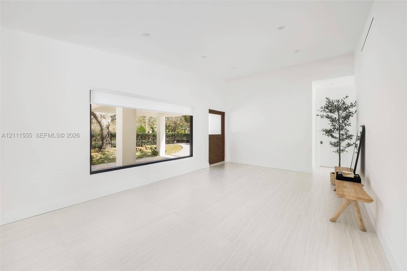 8800 SW 118th Street, Miami, Miami, FL 33176 Minimalist interior featuring light-toned flooring, expansive picture window, recessed ceiling lighting, and solid wood door