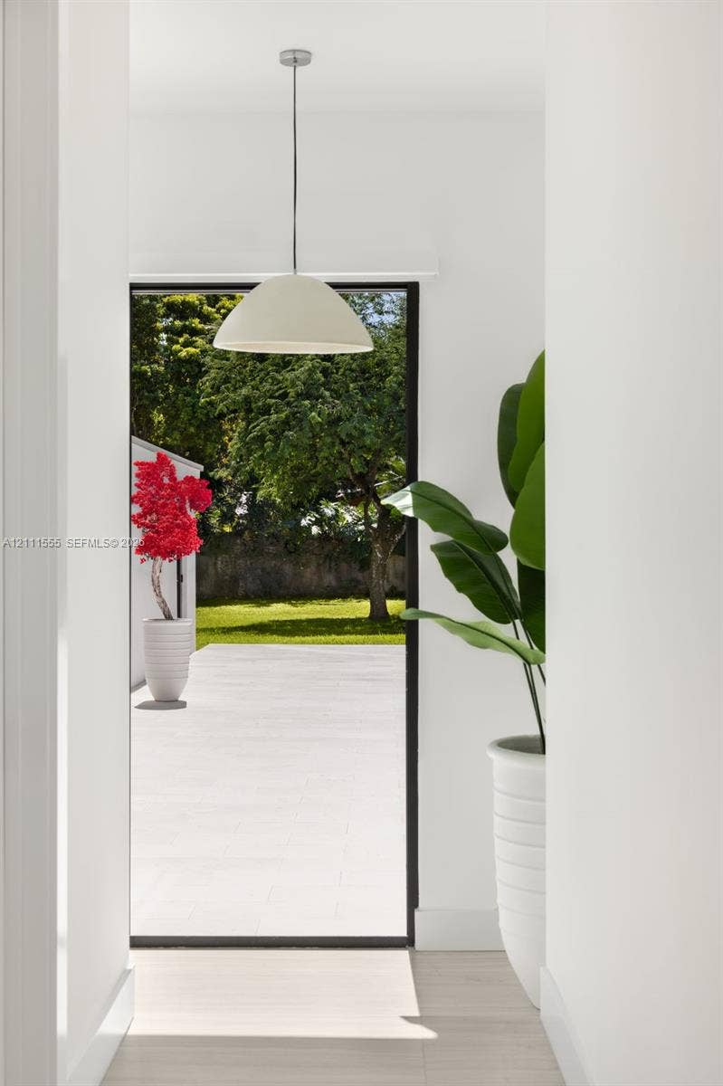 8800 SW 118th Street, Miami, Miami, FL 33176 Minimalist pendant lighting, wide-format glass door, and exterior stone patio