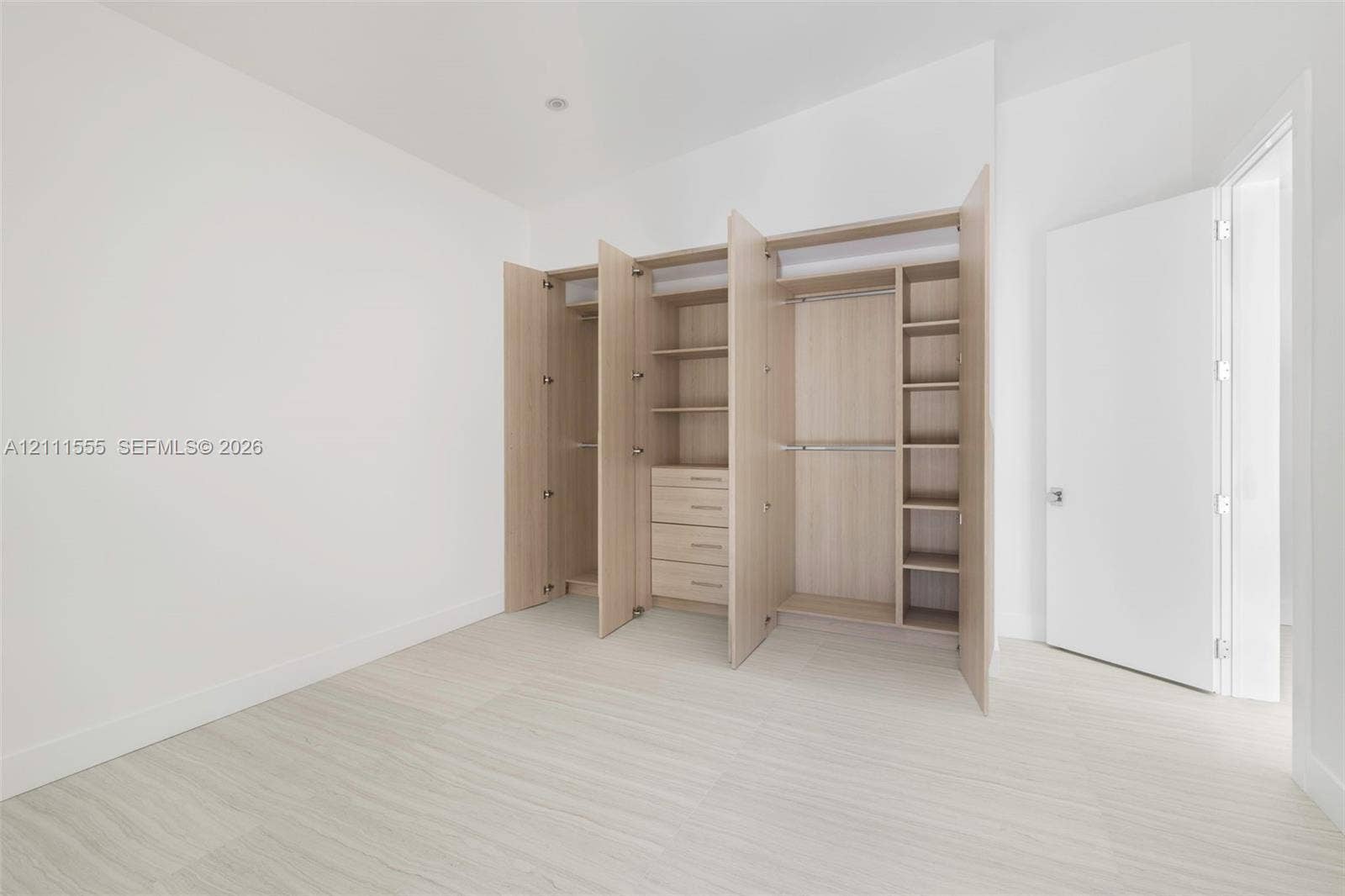 8800 SW 118th Street, Miami, Miami, FL 33176 Custom built-in wood-finish cabinetry featuring integrated shelving, hanging rods, and a four-drawer storage unit