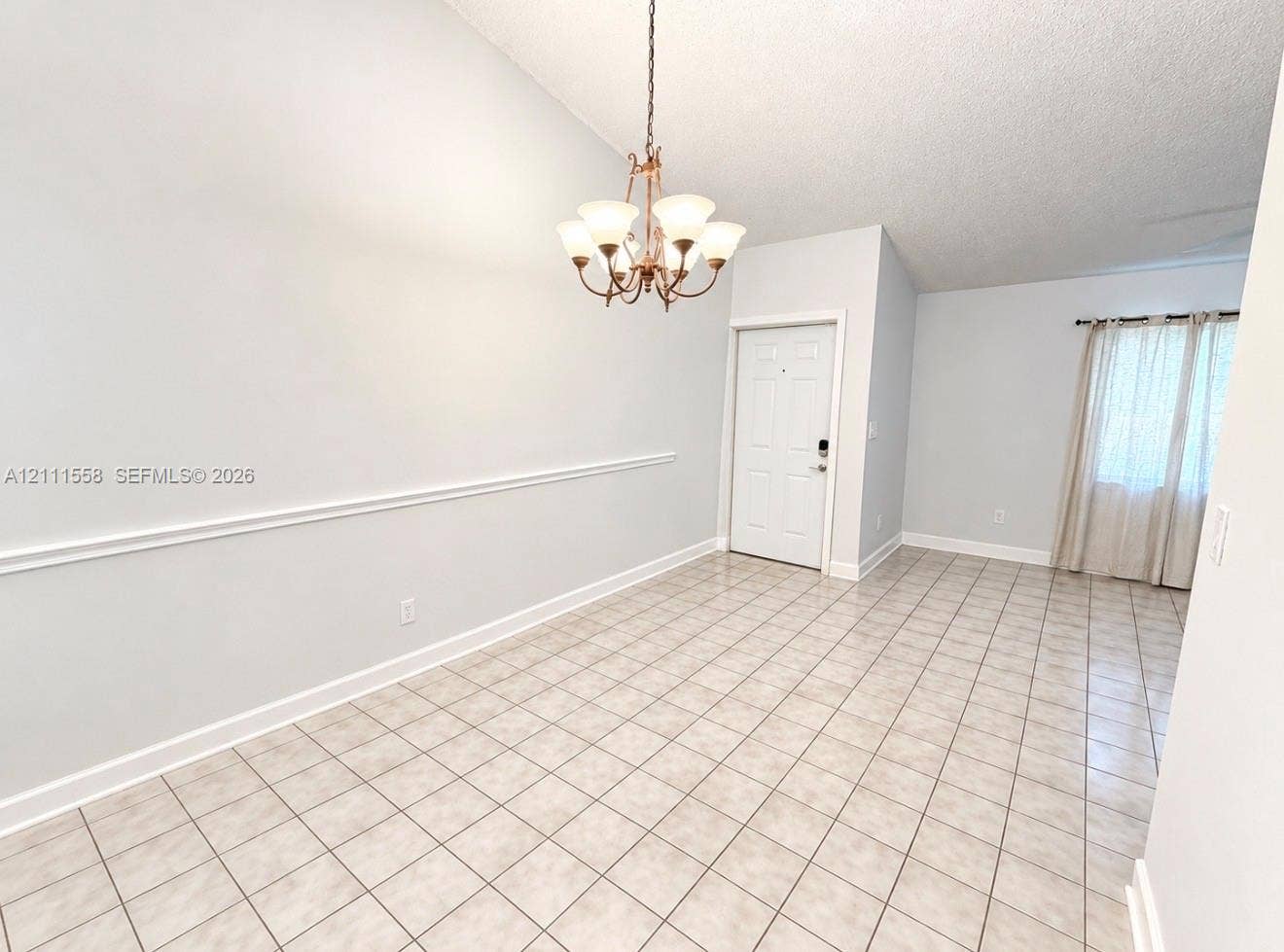 3652 NW 83rd Lane, #3652, Sunrise, Sunrise, FL 33351 Vaulted ceiling with an overhead chandelier, neutral ceramic tile flooring, and decorative wall molding