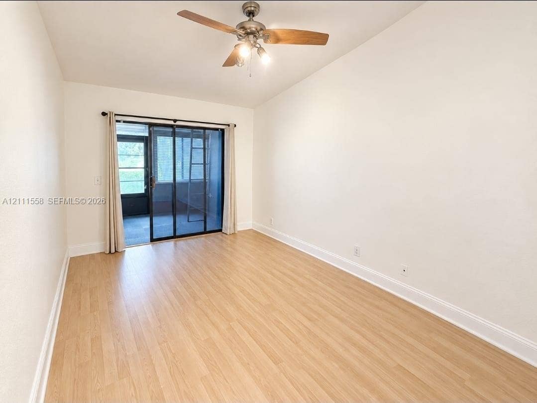 3652 NW 83rd Lane, #3652, Sunrise, Sunrise, FL 33351 Room featuring wood-finish flooring, a ceiling fan with integrated lighting, and a sliding glass door