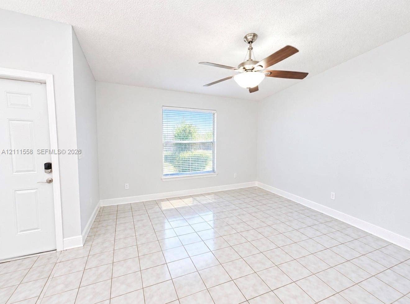 3652 NW 83rd Lane, #3652, Sunrise, Sunrise, FL 33351 Neutral-toned interior featuring ceramic tile flooring, a brushed nickel ceiling fan with integrated lighting, and a single-panel door with smart-lock hardware