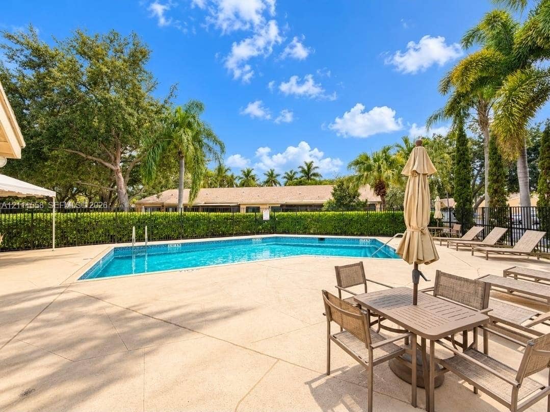 3652 NW 83rd Lane, #3652, Sunrise, Sunrise, FL 33351 In-ground swimming pool with a concrete pool deck, enclosed by perimeter fencing and landscaped hedging