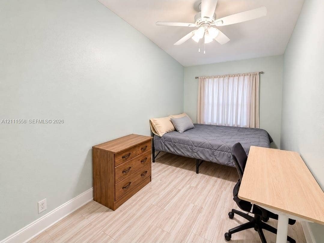 3652 NW 83rd Lane, #3652, Sunrise, Sunrise, FL 33351 Room featuring wood-finish flooring, a ceiling fan with integrated lighting, and a window with rod-mounted hardware