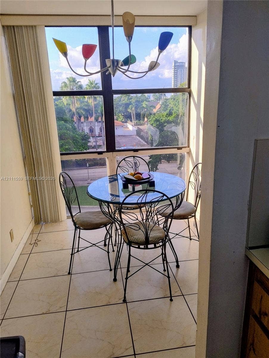 1915 Brickell Avenue, #C501, Miami, FL 33129 Floor-to-ceiling windows, tile flooring, and multi-colored chandelier featuring polished metal finish