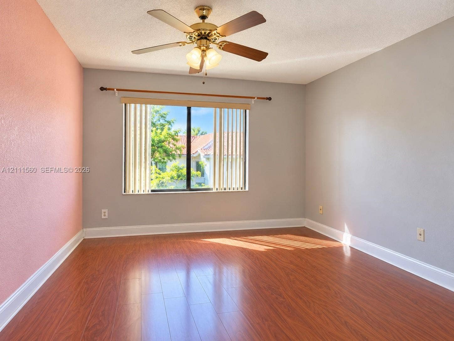 3539 W Inverrary Boulevard W, #1, Lauderhill, Lauderhill, FL 33319 Room featuring wood-finish flooring, a ceiling fan with integrated lighting, and a single window with vertical blinds