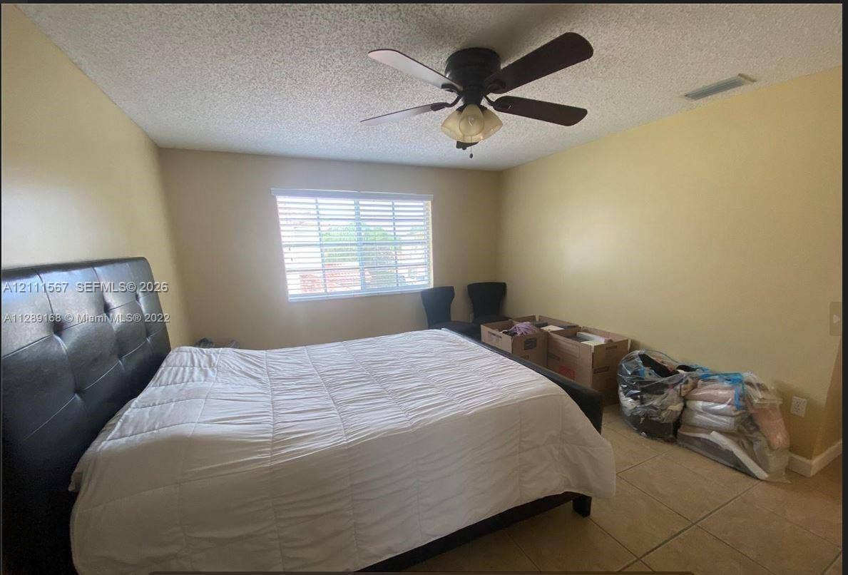 21514 SW 90th Avenue, Cutler Bay, FL 33189 Room featuring tile flooring, ceiling fan with integrated light fixture, and horizontal blind window treatments