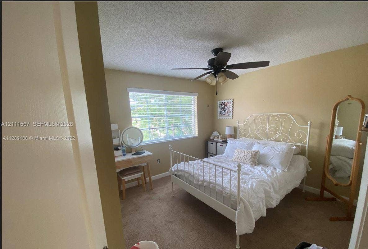 21514 SW 90th Avenue, Cutler Bay, FL 33189 Bedroom featuring neutral wall paint, carpeted flooring, a ceiling-mounted light fixture with a fan, and a single-pane horizontal window