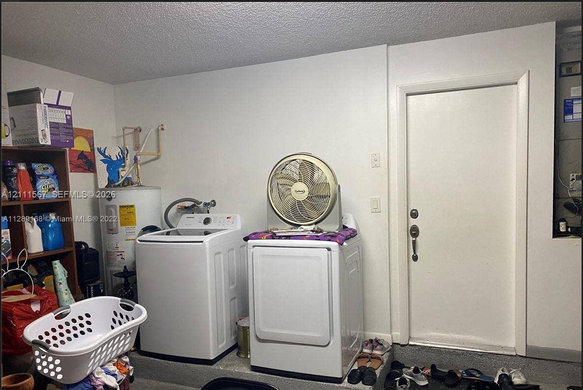 21514 SW 90th Avenue, Cutler Bay, FL 33189 Utility area featuring a cylindrical water heater, dedicated laundry hookups, and a solid-core interior door