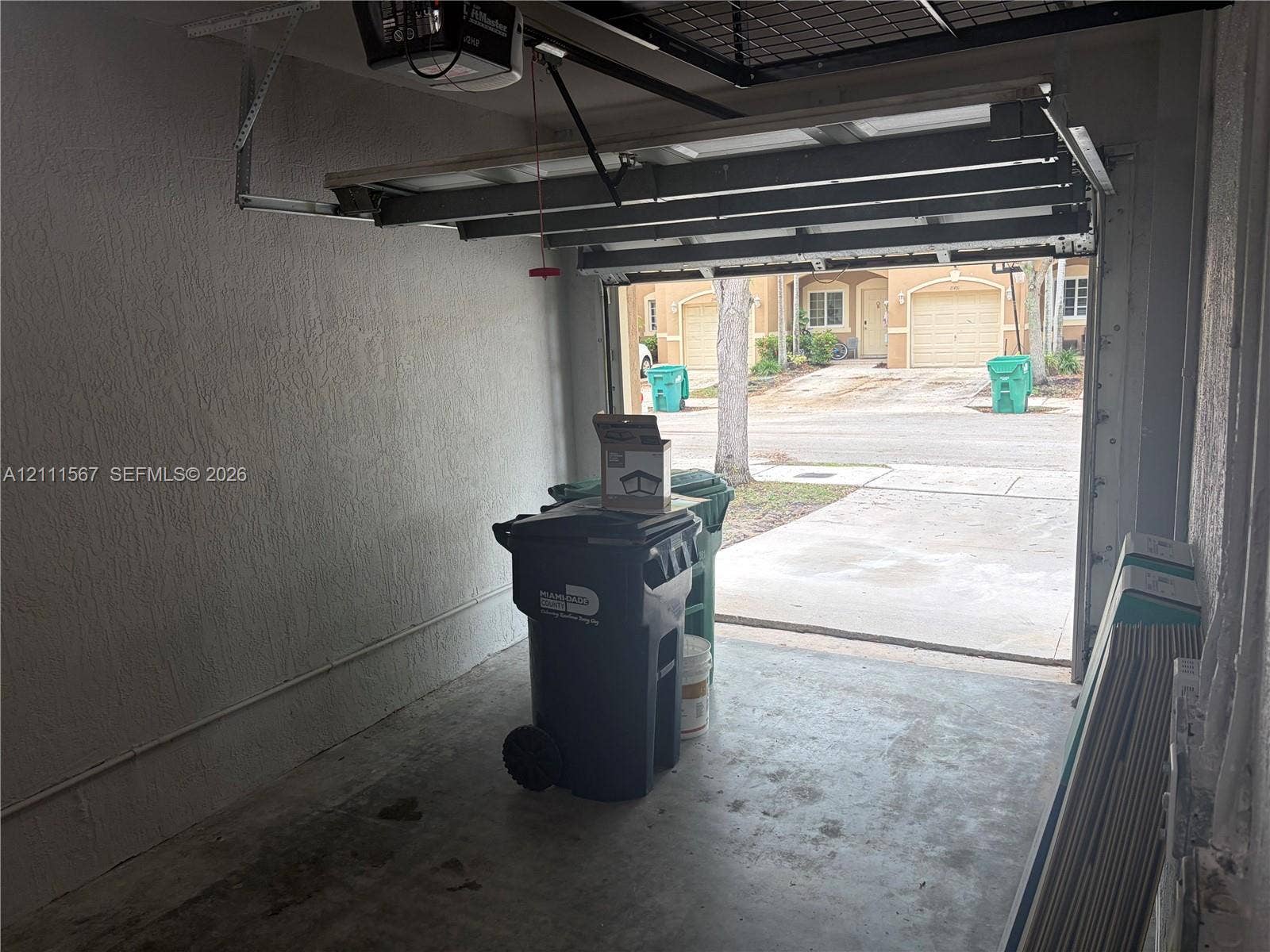 21514 SW 90th Avenue, Cutler Bay, FL 33189 Enclosed garage featuring a concrete floor, textured walls, and an overhead automatic door opener