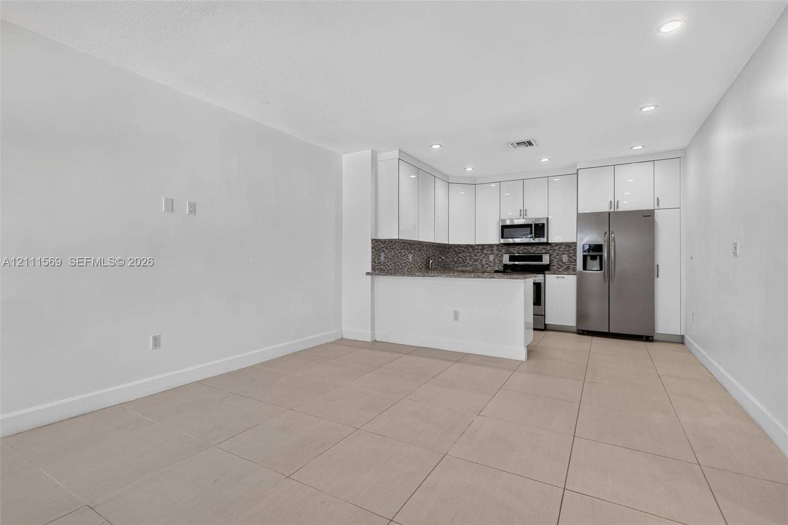 12800 NE 11th Avenue, #4, North Miami, North Miami, FL 33161 Kitchen featuring white high-gloss cabinetry, stone-finish countertops, mosaic tile backsplash, stainless steel appliances, and large-format tile flooring
