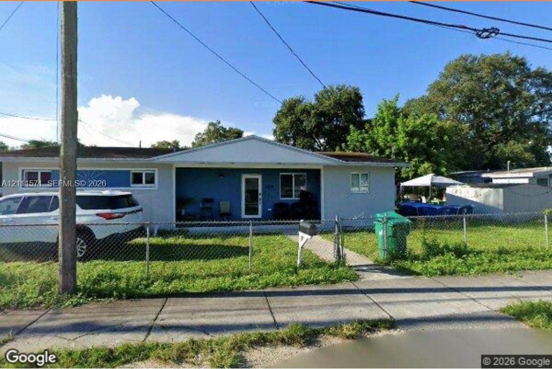 3100 NW 43rd Street, #0, Miami, Miami, FL 33142 Single-story residence featuring a recessed covered front porch, low-pitched roofline, and chain-link perimeter fencing