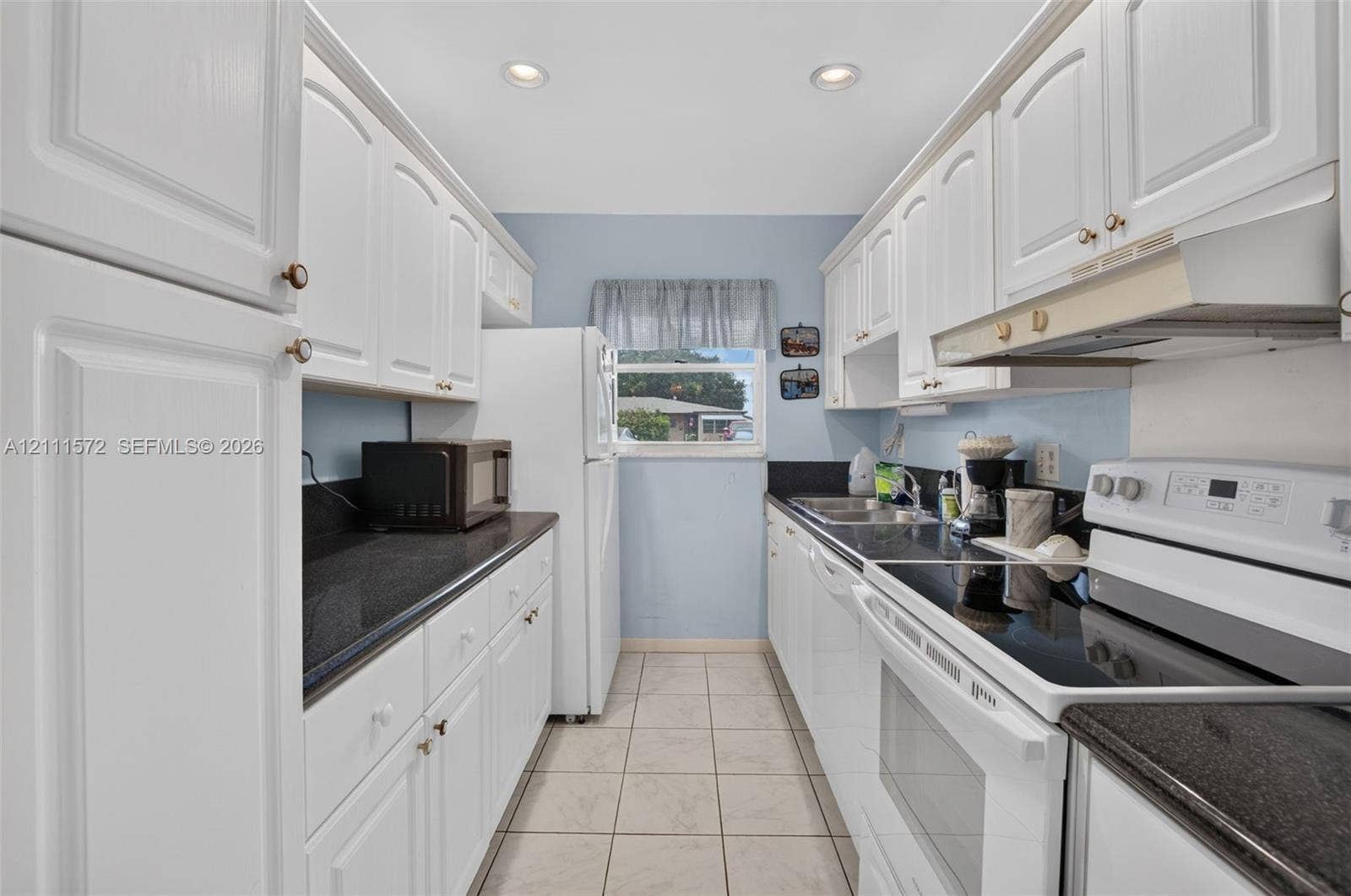 Kitchen featuring white cabinetry, stone-finish countertops, tile flooring, and recessed ceiling lighting